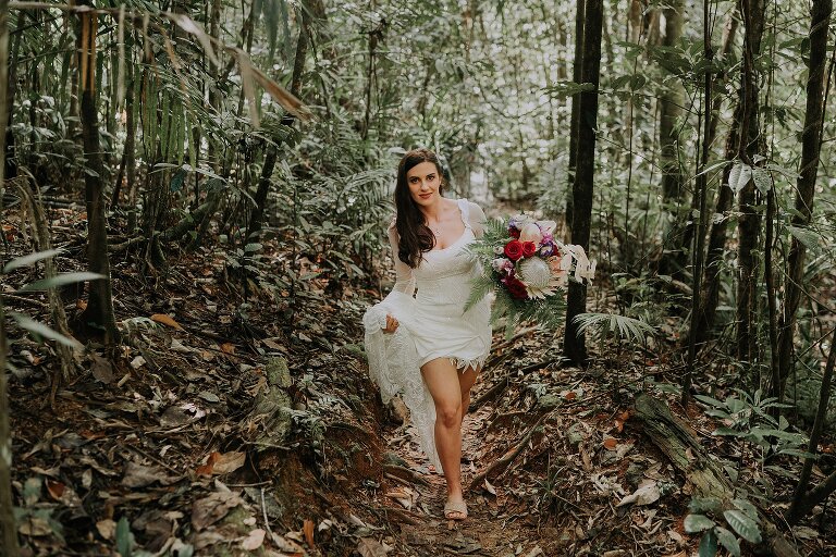 Bride walking through forest to waterfall at Daintree Ecolodge