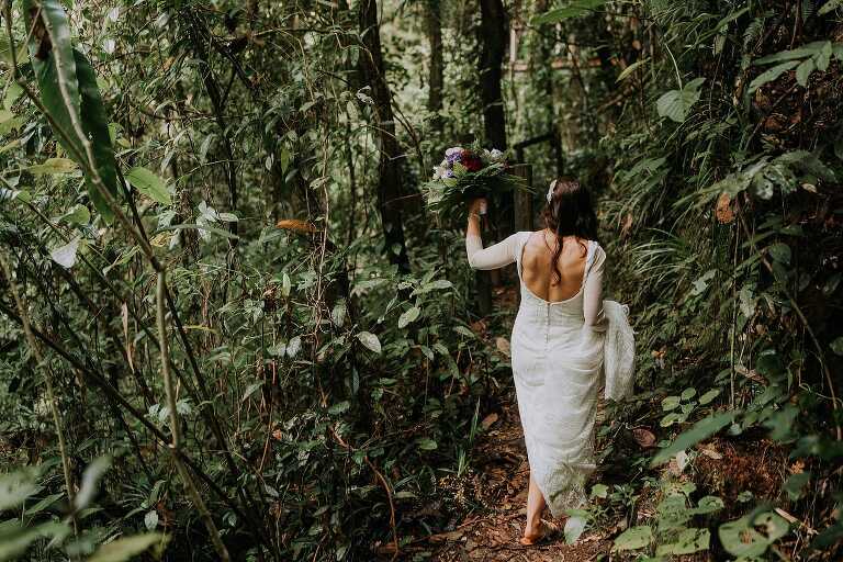 Bride in wedding dress walking in forest