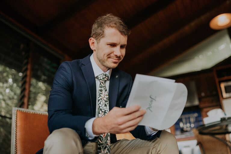 Groom reading note from bride on wedding morning